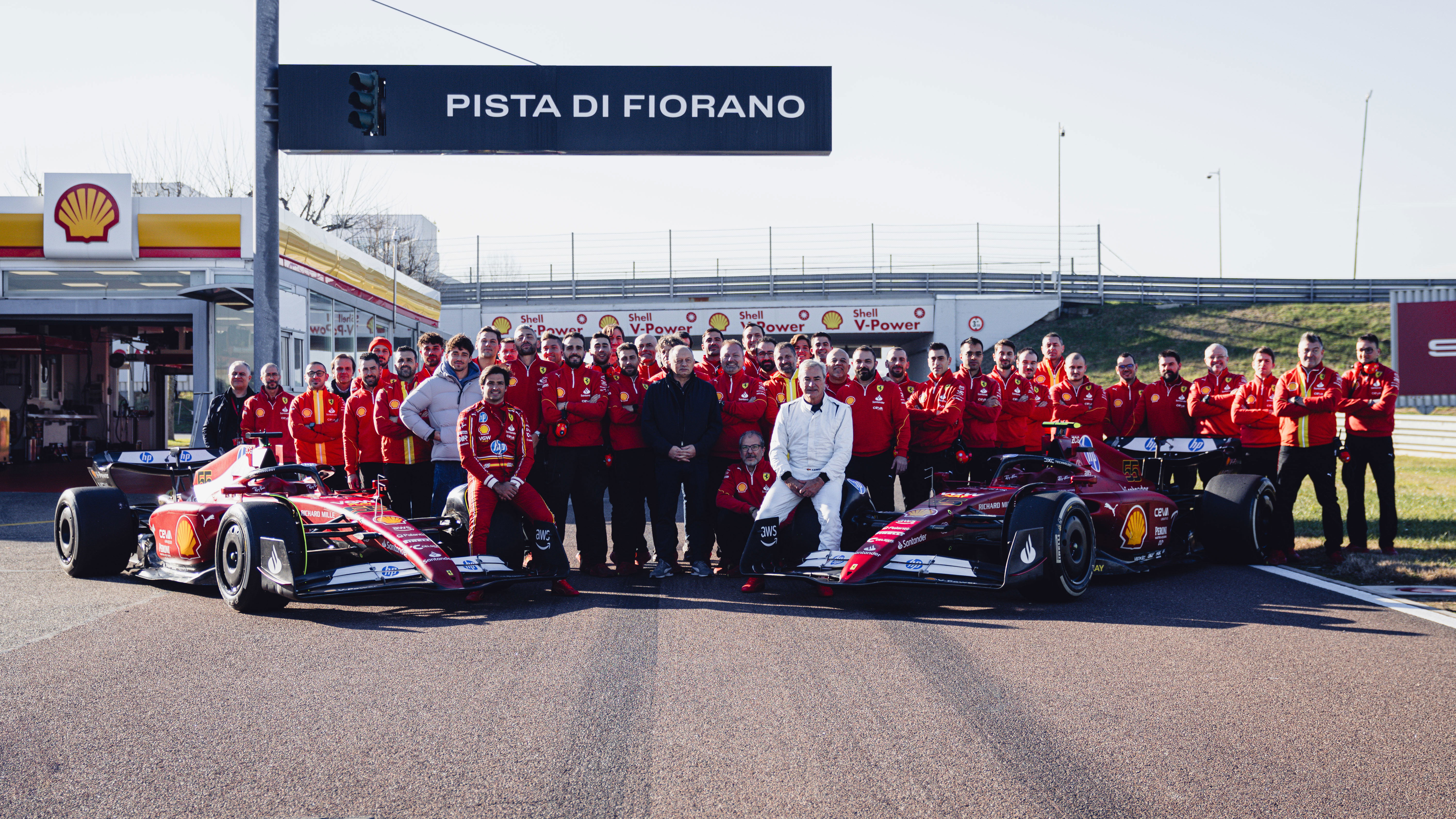 Carlos Sainz Jr. and Sr. with Ferrari F1 cars and team